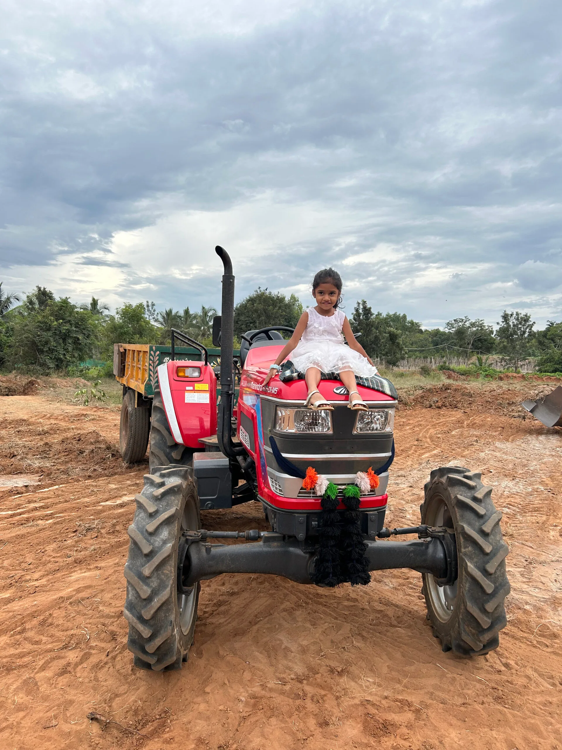 A child sitting on the farm tractor
