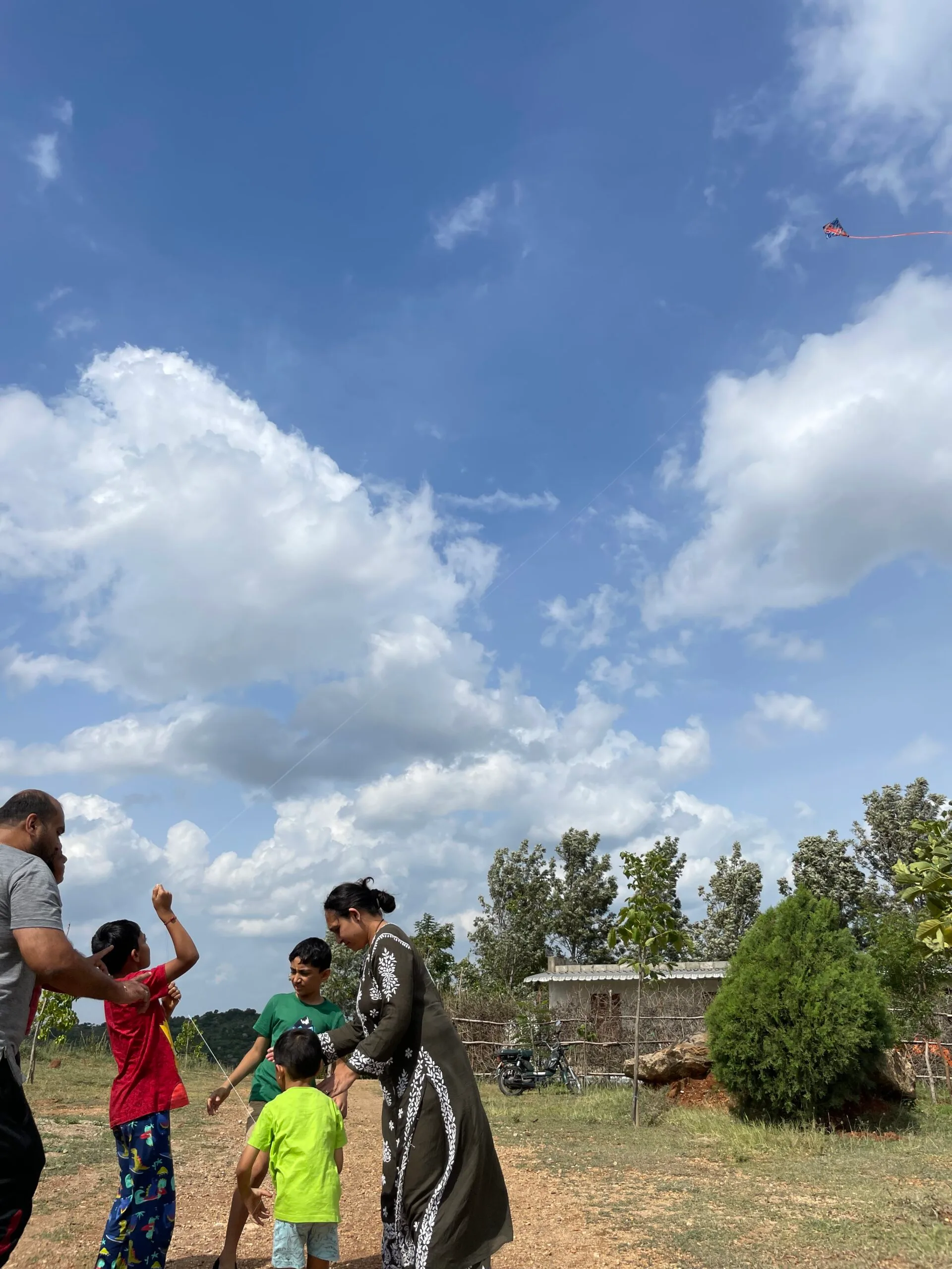 A family flying a kite on the open lawn at Ecoland Farms
