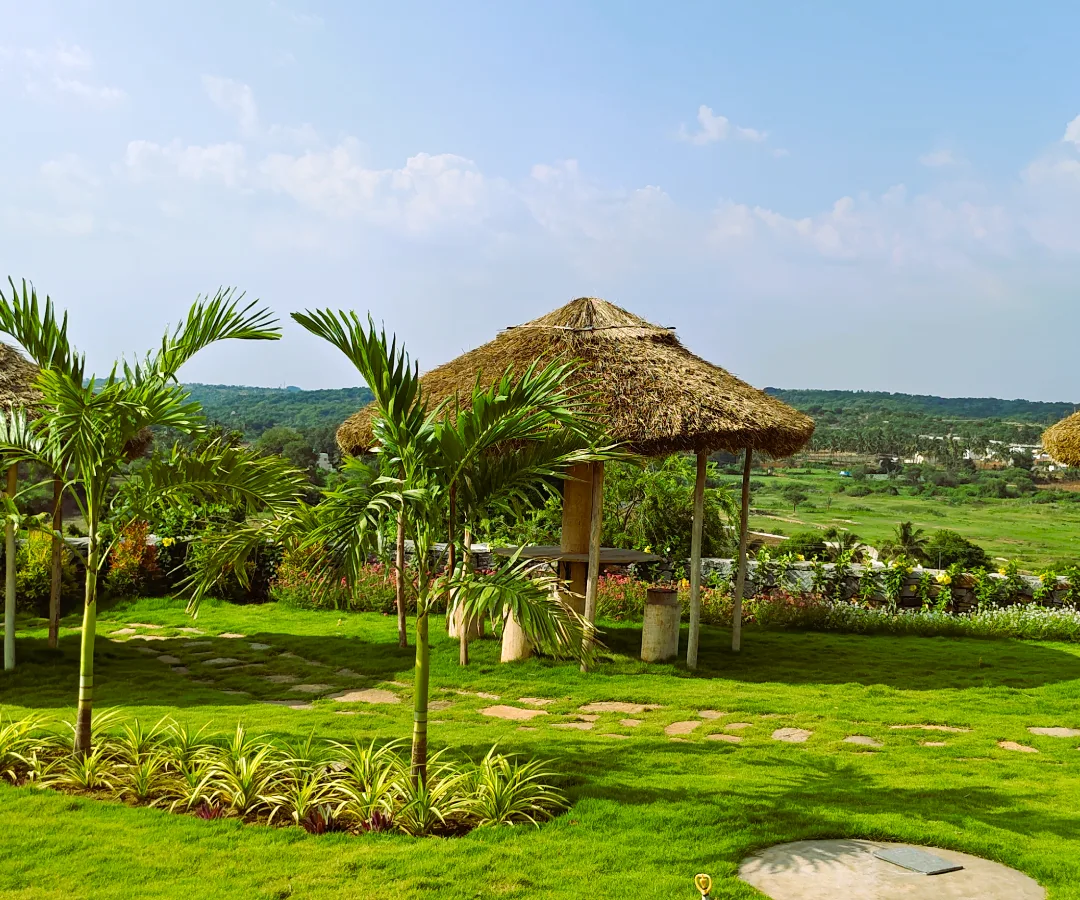 A thatched sit-out on the lawn with the valley beyond